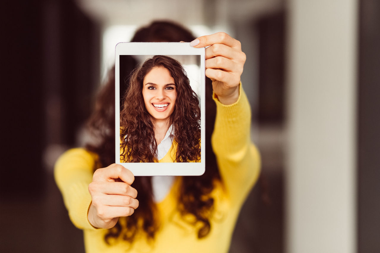 Smiling girl taking selfie with tablet